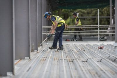 A construction worker is working on a steel structure.