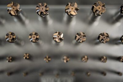 A row of metal drill bits in a metal rack.