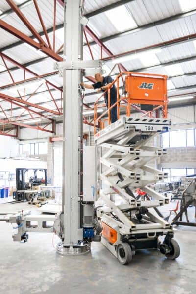 A man working on a lift in a warehouse.