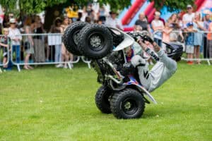 A man doing tricks on a quad bike in front of a crowd.