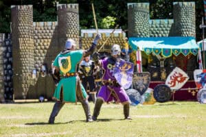 Two knights fighting in front of a castle.