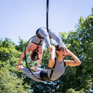 Two women doing acrobatics in a park.