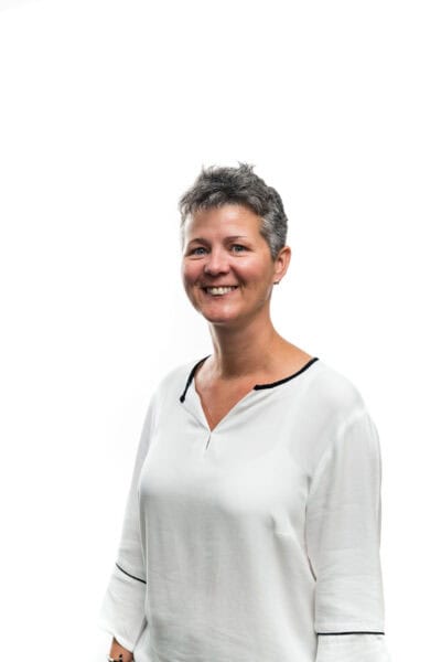A woman in a white shirt smiling for the camera.