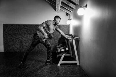 Black and white photo of a man working out in a gym.