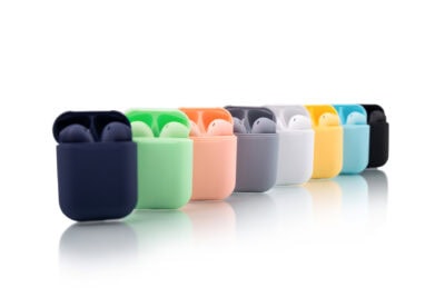 A row of different colored airpods on a white surface.