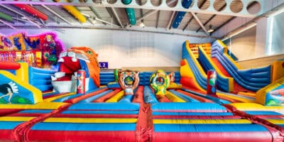 A large indoor play area with inflatables and slides.