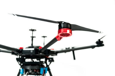 A black and red drone with propellers on a white background.