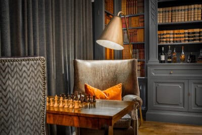 A chess board in a room with a lamp.