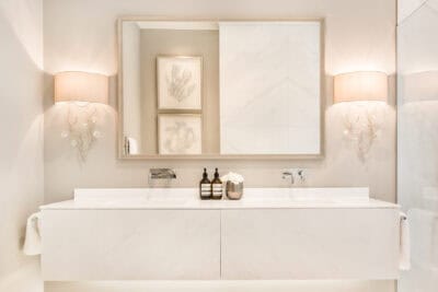 A white bathroom with two sinks and a mirror.