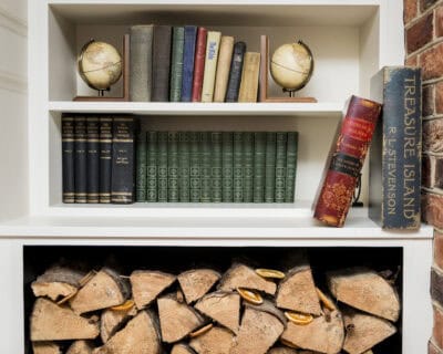 A bookcase with logs and books on it.