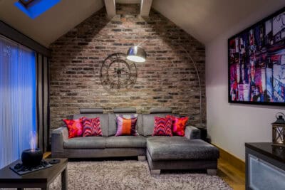 A living room with a brick wall.