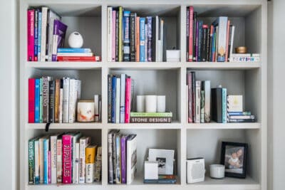 A white bookcase filled with books and other items.