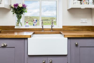 A kitchen with purple cabinets and a wooden sink.