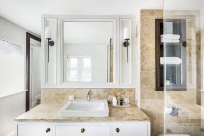 A bathroom with a white sink and mirror.