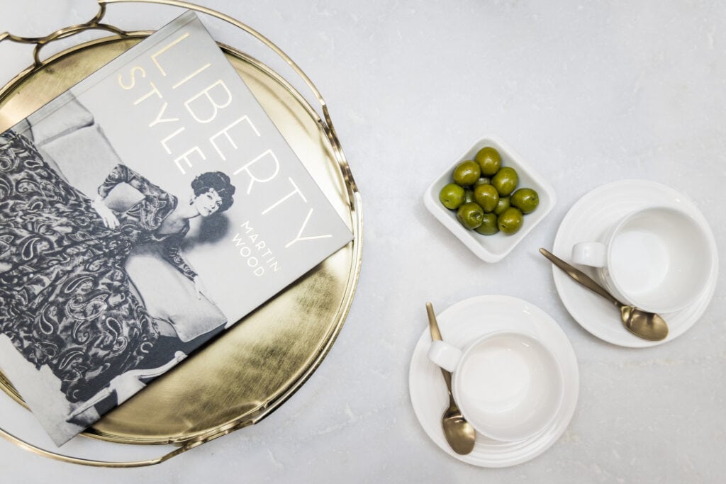 A tray with a book and olives on it.