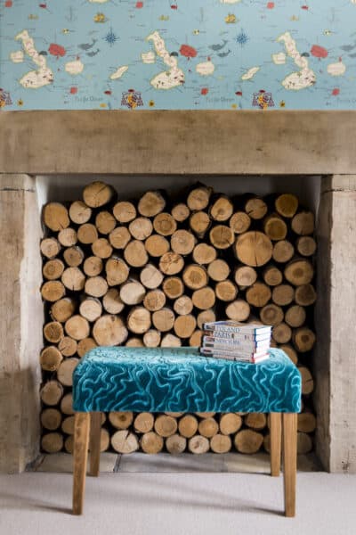 A blue bench sits in front of a wood burning fireplace.